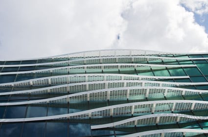 Undulating solar screens run along the lower part of the building, underscoring the water theme.